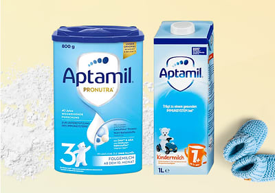 Zwei Aptamil Produktverpackungen: links eine blaue Folgemilch-Dose mit „Pronutra“ und „3“, rechts eine Kindermilch-Packung mit „1+“ und Bärchen-Illustration