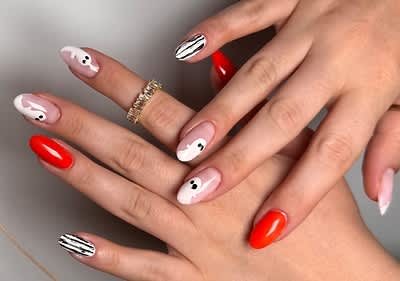 Nageldesign mit roten und schwarz-weiß gestreiften Nägeln und Geist-Mustern