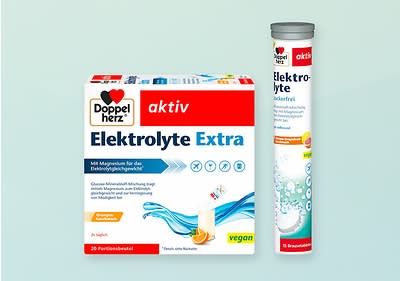 Eine Verpackung von Doppelherz aktiv Elektrolyte Extra mit 20 Portionsbeuteln und eine Röhrchenverpackung mit Brausetabletten, beide vegan und zuckerfrei