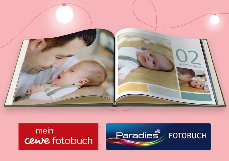 Ein geöffnetes Fotobuch zeigt Fotos eines lächelnden Mannes und eines Babys. Darunter die Logos von „mein cewe fotobuch“ und „Paradies FOTOBUCH“