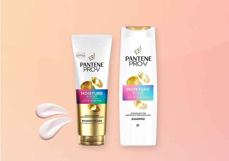 Eine weiße Shampoo-Flasche und eine Tube mit der Aufschrift „Pantene Pro-V Moisture Boost“ auf rosa Hintergrund, daneben zwei Creme-Tropfen