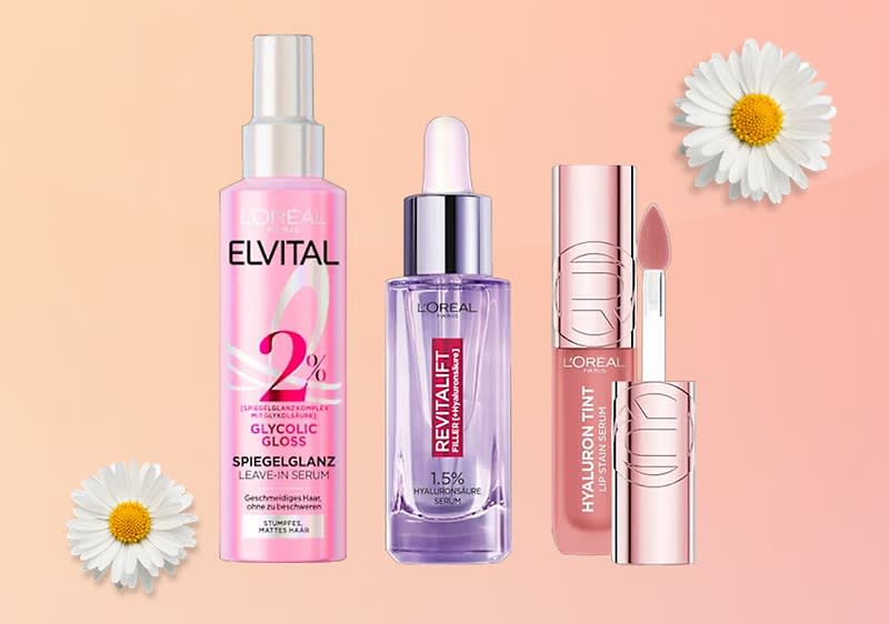 Drei L'Oréal-Produkte: Elvital Glycolic Gloss Spray, Revitalift Filler Serum und Hyaluron Tint Lippenstift, umgeben von zwei Gänseblümchen.