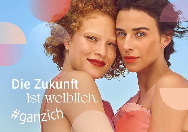 Zwei Frauen stehen nebeneinander vor einem blauen Hintergrund. Der Text „Die Zukunft ist weiblich. #ganzich“ ist in weißer Schrift zu sehen.