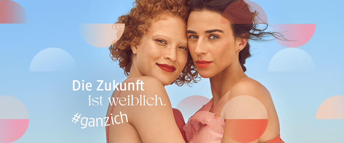 Zwei Frauen stehen nebeneinander vor einem blauen Hintergrund. Der Text „Die Zukunft ist weiblich. #ganzich“ ist in weißer Schrift zu sehen.