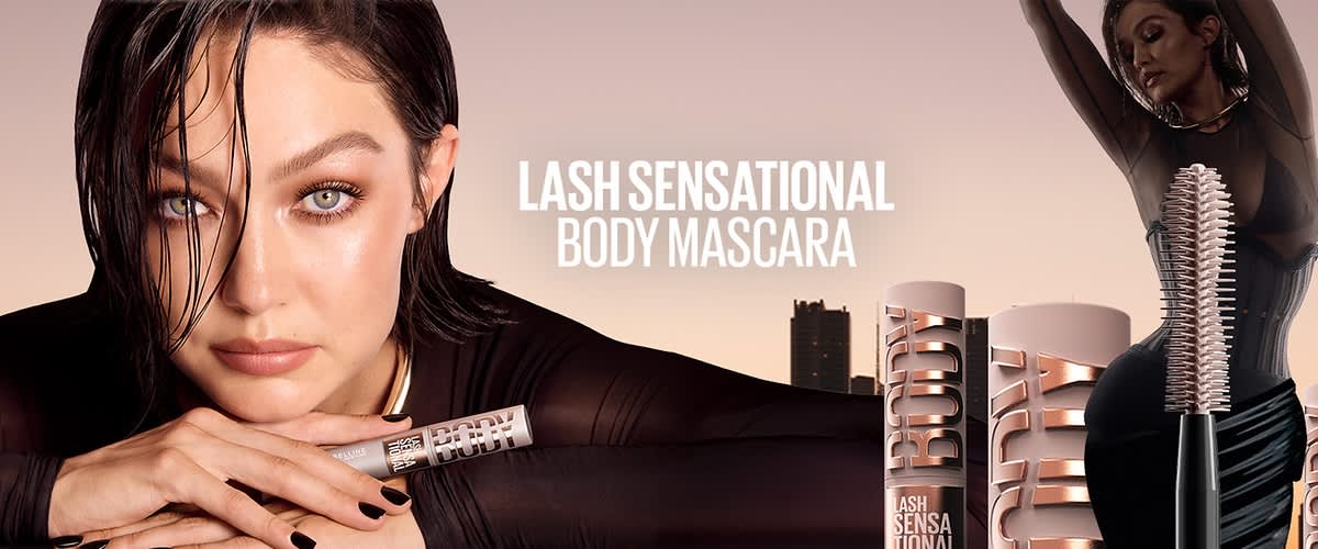 Eine Frau hält eine Tube mit der Aufschrift „Lash Sensational Body Mascara“ in der Hand. Der Hintergrund ist hellbraun.