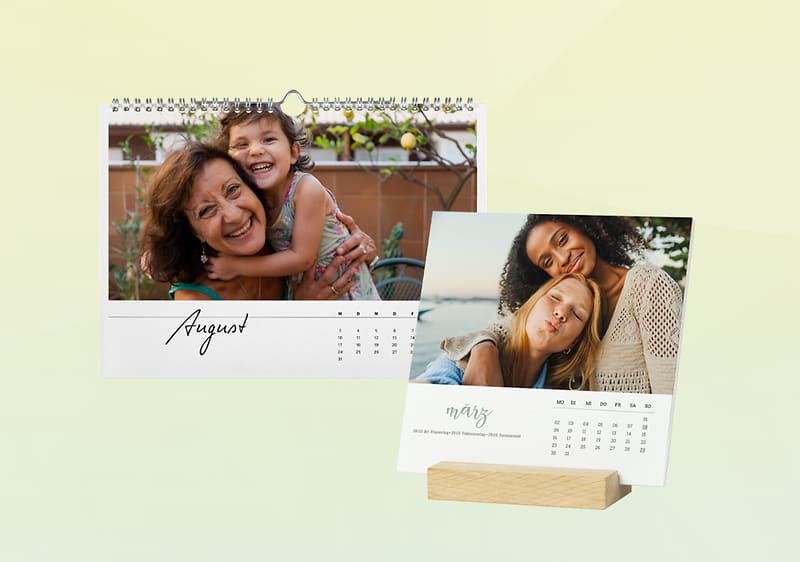 Zwei Kalender: links ein Wandkalender für August mit Foto zweier umarmender Personen, rechts ein Tischkalender für März mit Foto eines lächelnden Paares auf einem Holzständer