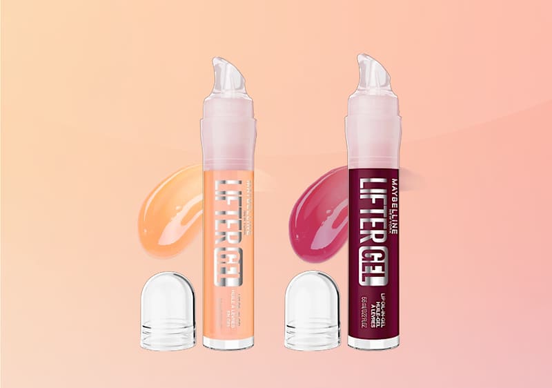 Zwei Maybelline Lift Erase Lip-Gel-Tuben nebeneinander, links pfirsichfarbene Verpackung mit passender Gelprobe, rechts dunkelrotschwarze Verpackung mit roter Gelprobe, beide mit durchsichtigen Kappen