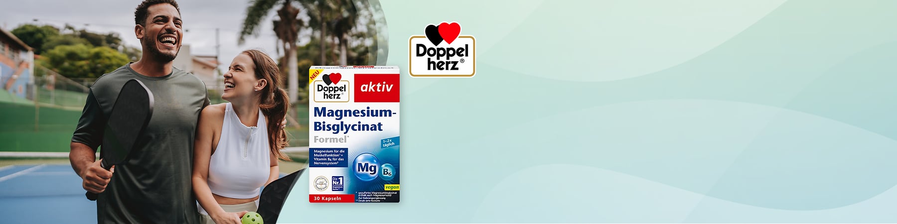 Packung Doppelherz aktiv Magnesium-Bisglycinat Formel, weiß-rot-blaues Design, Aufschrift „Magnesium-Bisglycinat Formel“, „30 Kapseln“, „Mg B6“ und „vegan“, links nebeneinander verschwommene Personen und Palmen im Hintergrund