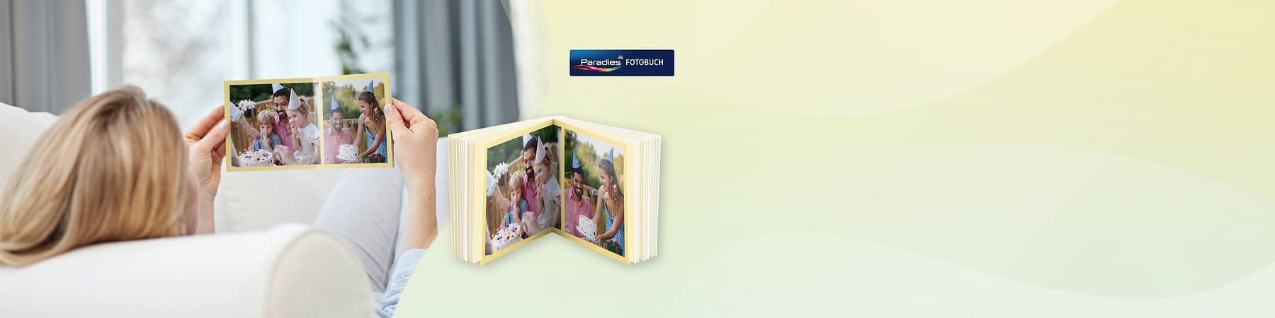 Person hält Fotokarte, davor aufgeschlagenes Fotobuch mit Familienfotos von Geburtstagsfeier und dem Logo „Paradies FOTOBUCH“