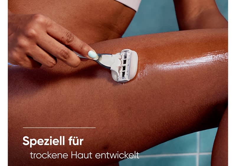 Eine Hand rasiert mit einem weißen Rasierer ein eingecremtes Bein, Text unten links: „Speziell für trockene Haut entwickelt“