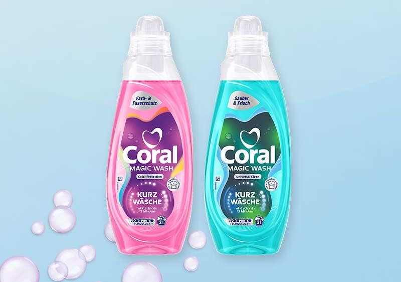 Zwei Coral Magic Wash Flüssigwaschmittel-Flaschen nebeneinander, links pink mit Aufschrift „Color Protection“ und „Kurz Wäsche“, rechts türkis mit Aufschrift „Universal Clean“ und „Kurz Wäsche“, Seifenblasen am unteren Rand