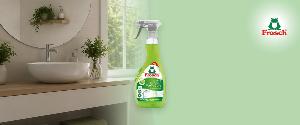 Grünes Frosch-Logo oben rechts, links eine grüne Sprühflasche „Frosch Dusche & Bad-Reiniger Weinsäure“, rechts eine gezeichnete Froschfigur in gelb-roter Badehose wischt ein Waschbecken