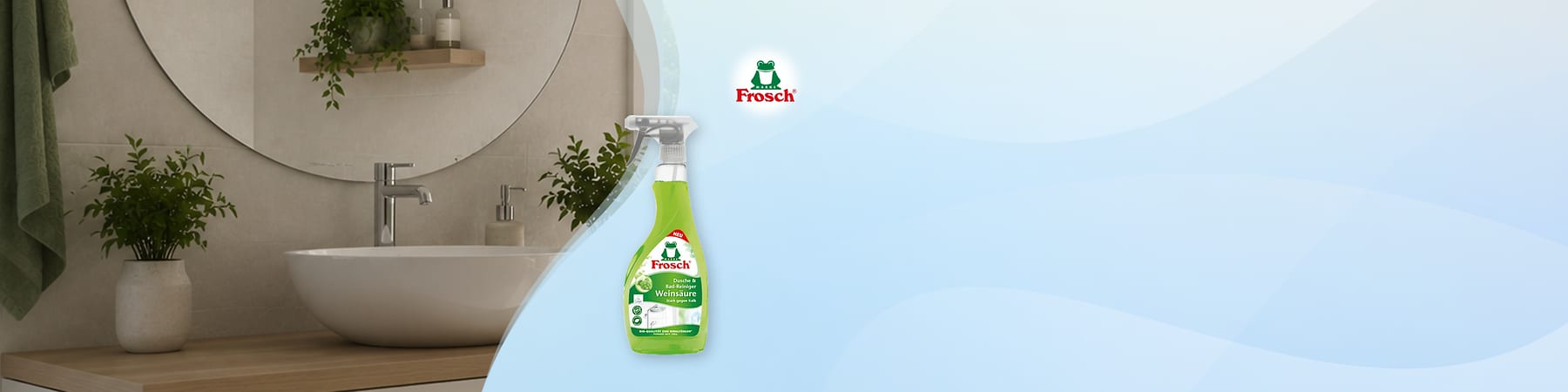 Grüner Frosch-Reiniger in transparenter Sprühflasche mit weißem Sprühkopf und Etikett „Frosch“, Produktname „Weißingere“ vor blauem Hintergrund rechts, links ein modernes Waschbecken mit runder Spiegel und Holzablage