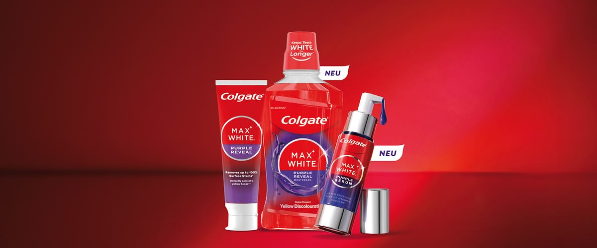 Drei rote Colgate MAX WHITE Purple Reveal Produkte nebeneinander: links Tube mit Aufdruck „MAX WHITE PURPLE REVEAL“, Mitte Mundspülflasche mit Colgate-Logo und Hinweis „Yellow Discolouration“, rechts Pumpspender mit Etikett „MAX WHITE PURPLE SERUM“ und abnehmbare silberne Kappe, auf rotem Hintergrund, zwei kleine weiße Fähnchen mit Text „NEU“