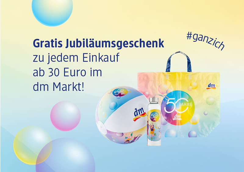 Werbeabbildung mit Text „Gratis Jubiläumsgeschenk zu jedem Einkauf ab 30 Euro im dm Markt!“ links und rechts eine Pastell-Tasche mit Aufdruck „50 Jahre“, eine Strandball-ähnliche Kugel mit dm-Logo und eine Trinkflasche vor buntem Bubble-Hintergrund