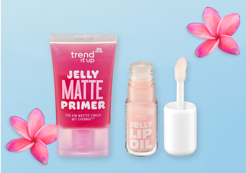 Rosa Tube mit der Aufschrift „trend it up JELLY MATTE PRIMER“ links und daneben ein kleiner Flakon mit Applikator und der Aufschrift „JELLY LIP OIL“, alles vor hellem blauem Hintergrund mit zwei pinken Blüten jeweils oben rechts und unten links