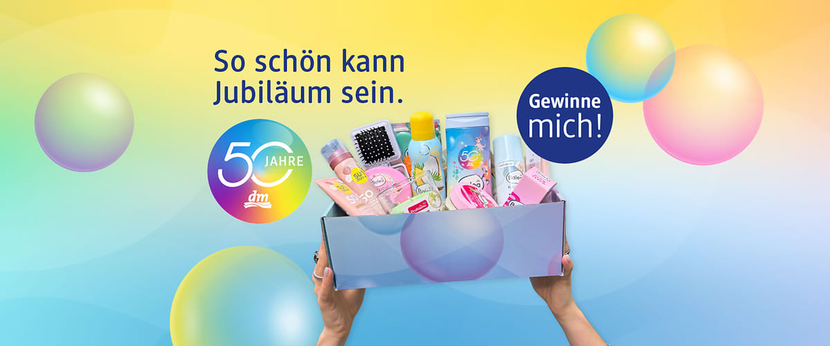 Bunte Jubiläums-Geschenkbox mit dm-Logo und Aufschrift „50 Jahre“, Hände halten eine offene Schachtel mit Pflegeprodukten wie Lotion, Deodorant, Zahnpasta, Haarbürste und Verpackungen, Text „So schön kann Jubiläum sein“ und Kreisbutton „Gewinne mich“