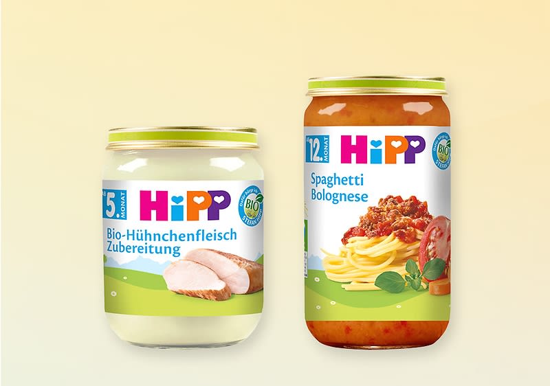 Zwei Gläser Babygläschen der Marke HiPP nebeneinander: links weiß-cremige „Bio-Hühnchenfleisch Zubereitung“ mit Bild von Hühnerbrust, rechts rotes Glas „Spaghetti Bolognese“ mit Spaghetti und Bolognesesauce sowie HiPP-Logo und Bio-Siegel