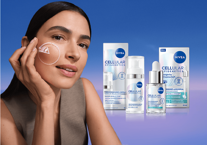 Frau mit dunklen Haaren streicht mit der Hand sanft über die rechte Wange, auf der ein weißer gestrichelter Kreis mit Pfeil als Pflege-Piktogramm zu sehen ist, rechts daneben drei NIVEA Cellular Epigenetics Pflegeprodukte in ihrer Verpackung auf blauem Verlaufshintergrund