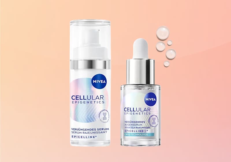 Zwei NIVEA Cellular Epigenetics Produkte auf hellem rosa Verlaufshintergrund: links eine weiße Pumpflasche mit silbernem Hals und Aufschrift „CELLULAR EPIGENETICS Verjüngendes Serum EPICELLINE“, rechts ein Glas-Fläschchen mit Pipette und ähnlichem Etikett sowie vier klare Serum-Tropfen daneben