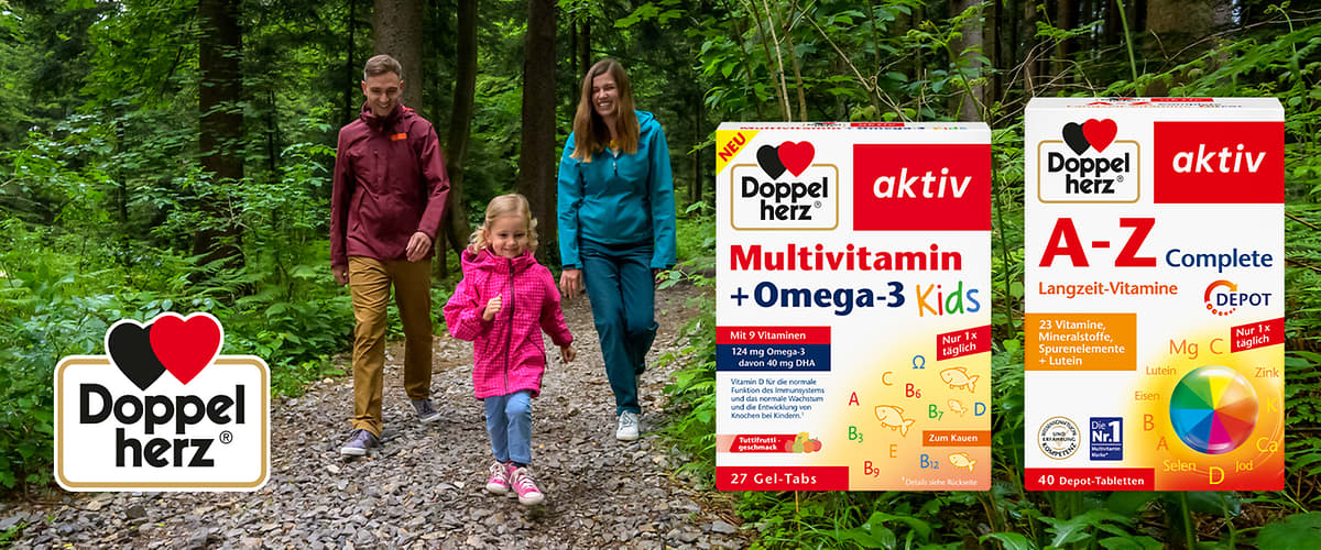 Zwei Doppelherz aktiv Nahrungsergänzungsmittelpackungen nebeneinander vor Waldhintergrund: links eine weiße Box mit rotem Bereich „Multivitamin + Omega‑3 Kids“ und bunten Icons, Hinweis „27 Gel‑Tabs“; rechts eine weiße Box mit rotem Bereich „A‑Z Complete Langzeit‑Vitamine“ und farbigem Vitaminkreis, Hinweis „40 Depot‑Tabletten“