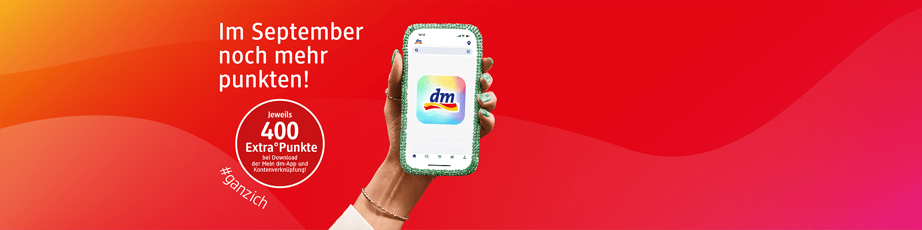 Rote Werbefläche mit Hand, die ein Smartphone mit grün glitzernder Hülle und dem dm-App-Logo hält; links Text: „Im September noch mehr punkten!“ und Kreis mit „Jeweils 400 Extra Punkte bei Download der Mein dm‑App und Kontenverknüpfung“