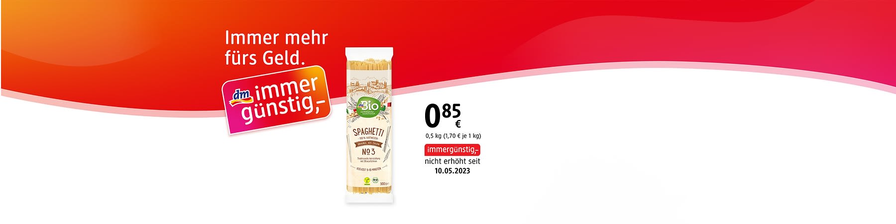 Auf weiß-rotem Hintergrund links das orange-rosa Logo „dm immer günstig“ und der Schriftzug „Immer mehr fürs Geld“, mittig eine Packung Bio-Spaghetti mit Aufschrift „Spaghetti No 3“ und grünem „Bio“-Label, rechts Preis „0,85 € (0,5 kg)“ und Hinweis „immergünstig, nicht erhöht seit 10.05.2023“