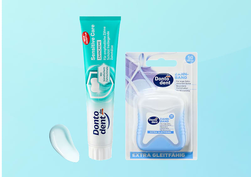 Zahnpasta-Tube „Dontodent Sensitive Care“ in türkis-weiß mit offener Kappe, rechts daneben Verpackung mit „Dontodent Zahn-Band Extra gleitfähig“ und einer kleinen Zahnpastatube-Tropfenprobe auf hellem türkisfarbigem Hintergrund