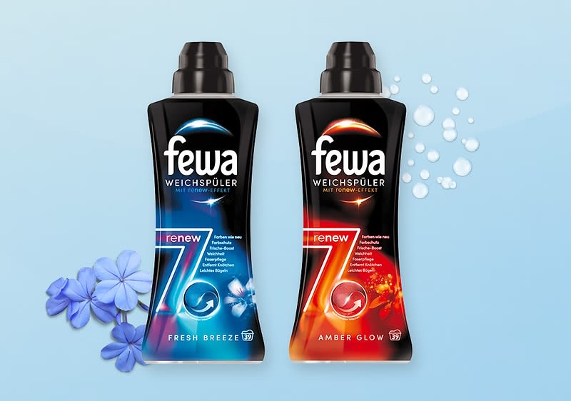 Zwei schwarze Flaschen Weichspüler der Marke „fewa“, links mit blauem Etikett „renew 7 Fresh Breeze“ und blauer Blüte, rechts mit rotem Etikett „renew 7 Amber Glow“ und blassen Blasen als Deko