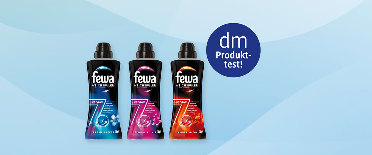 Drei schwarze Flaschen Weichspüler der Marke Fewa nebeneinander: links „Fresh Breeze“ mit blauem Design und Aufschrift „renew 7“, Mitte „Floral Elixir“ mit pinkem Design und Aufschrift „renew 7“, rechts „Amber Glow“ mit orange-rotem Design und Aufschrift „renew 7“, oben rechts runder blauer Kreis mit weißer Schrift „dm Produkttest“