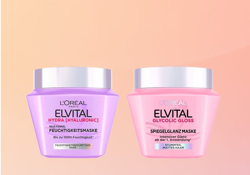 Zwei runde Elvital Haarmasken-Dosen nebeneinander auf pastellfarbenem Hintergrund; links lilafarbene Dose mit silbernem Deckel und Aufschrift „L'Oréal Paris Elvital Hydra [Hyaluronic] Feuchtigkeitsmaske bis zu 100H Feuchtigkeit“, rechts rosa Dose mit silbernem Deckel und Aufschrift „L'Oréal Paris Elvital Glycolic Gloss Spiegelglanz Maske intensiver Glanz ab der 1. Anwendung“