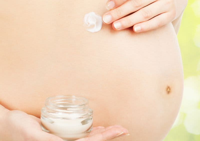 Mama cremt sich Babybauch ein