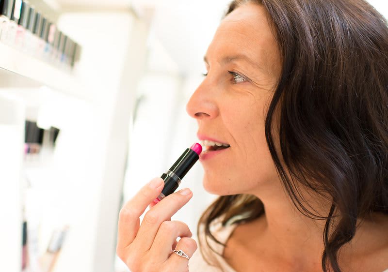 Frau trägt Lippenstift auf