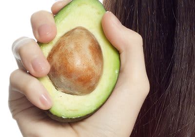 Frau mit Avocado in der Hand 