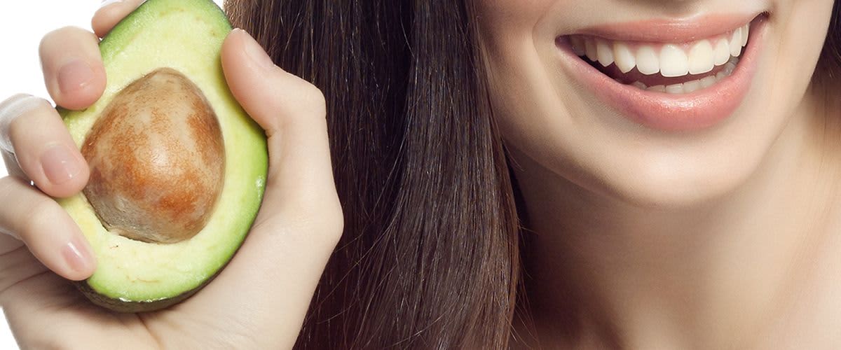 Frau mit Avocado in der Hand 