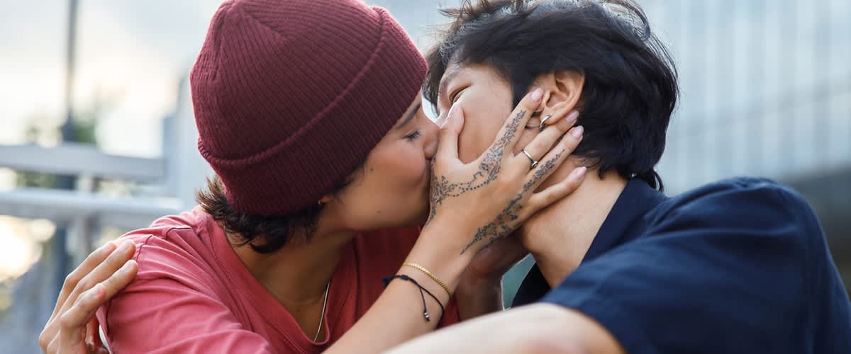 Frau mit Mütze küsst einen Mann