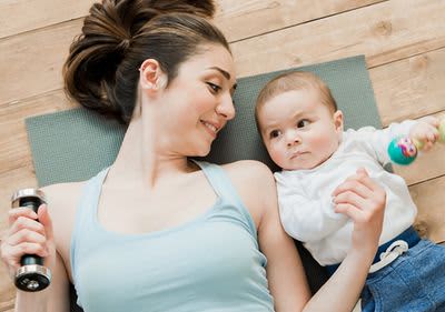 Mama sportelt neben Baby