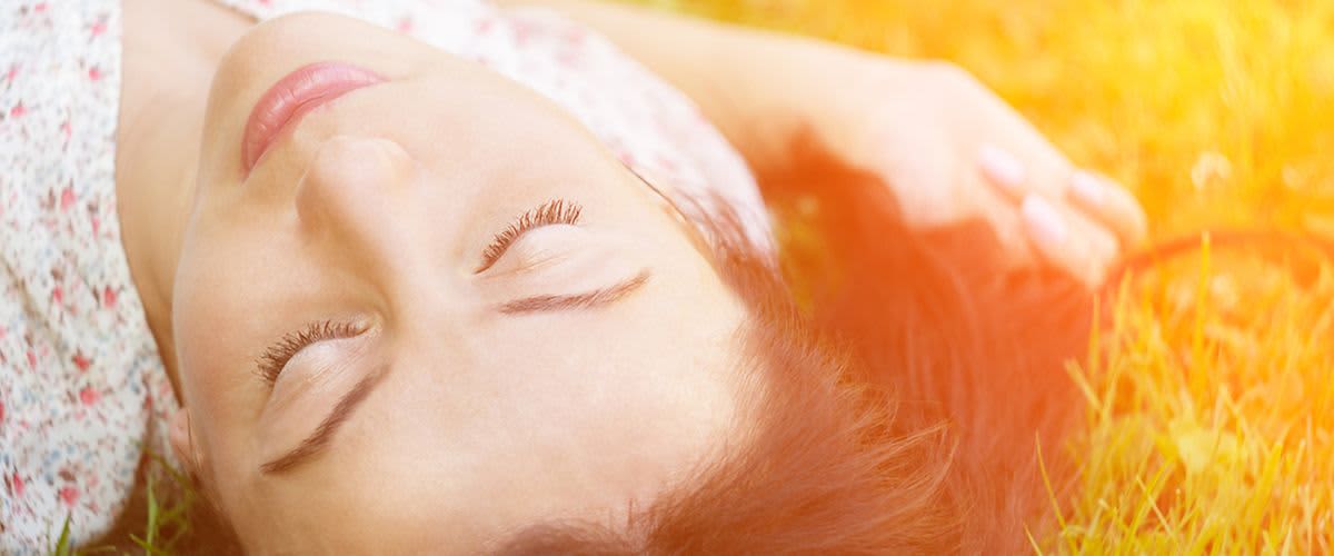 Frau liegt im Gras und schläft