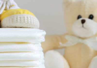 Windeln, Babyschuhe und ein Teddybär.