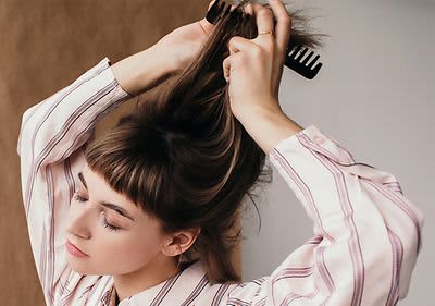 Frau kämmt sich Haare