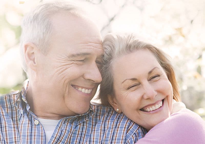 Lachendes älteres Paar umarmt sich