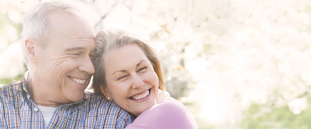 Lachendes älteres Paar umarmt sich