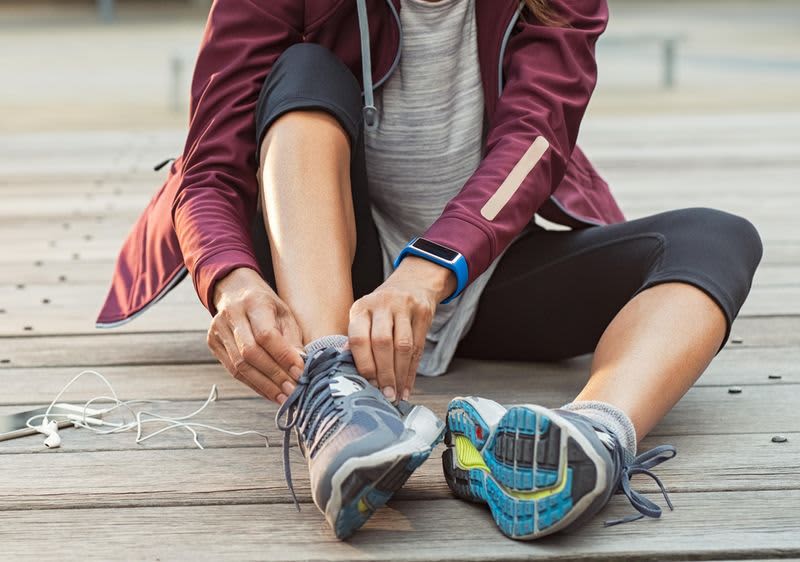 Frau bindet sich die Laufschuhe 