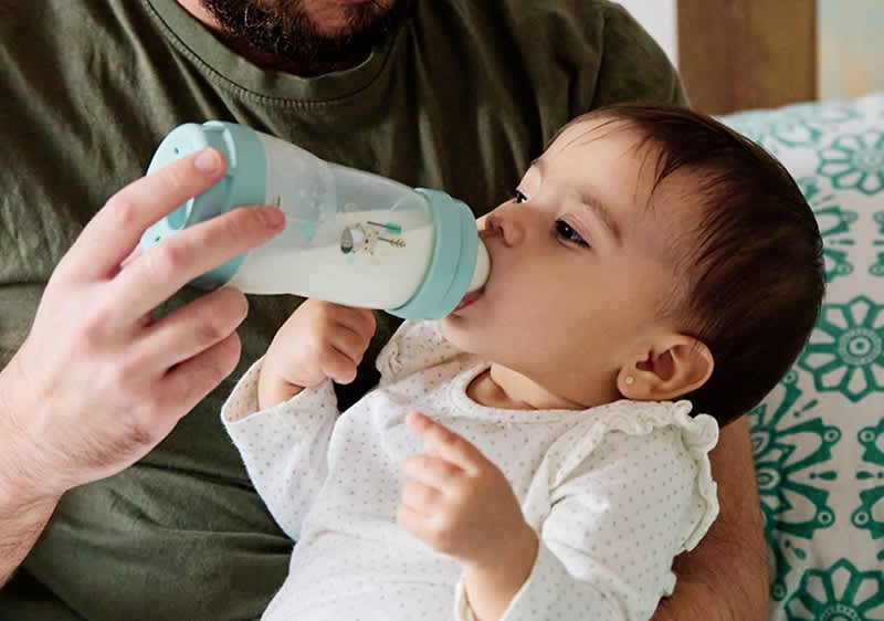 Vater füttert Baby mit Fläschchen
