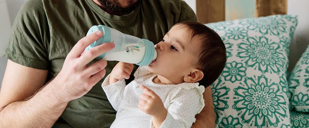 Vater füttert Baby mit Fläschchen