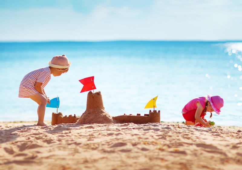 Kinder spielen am Strand