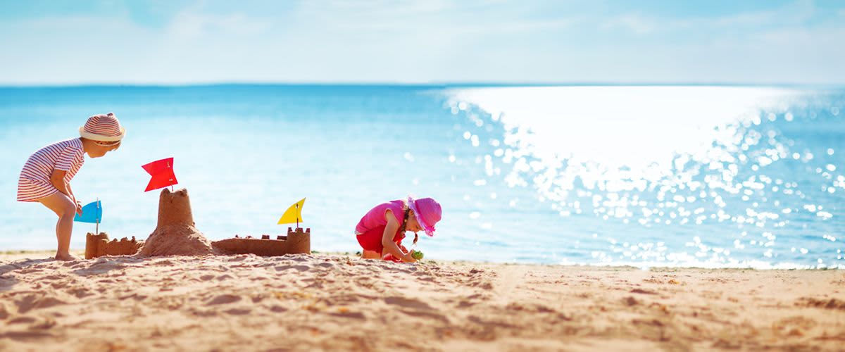Kinder spielen am Strand