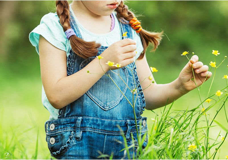 Kind läuft über Blumenwiese