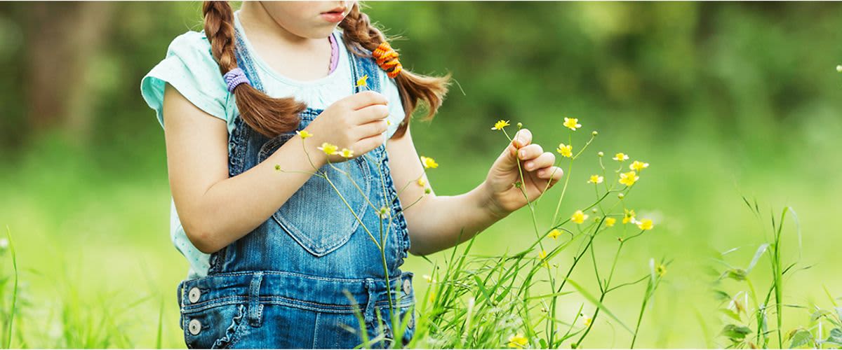 Kind läuft über Blumenwiese