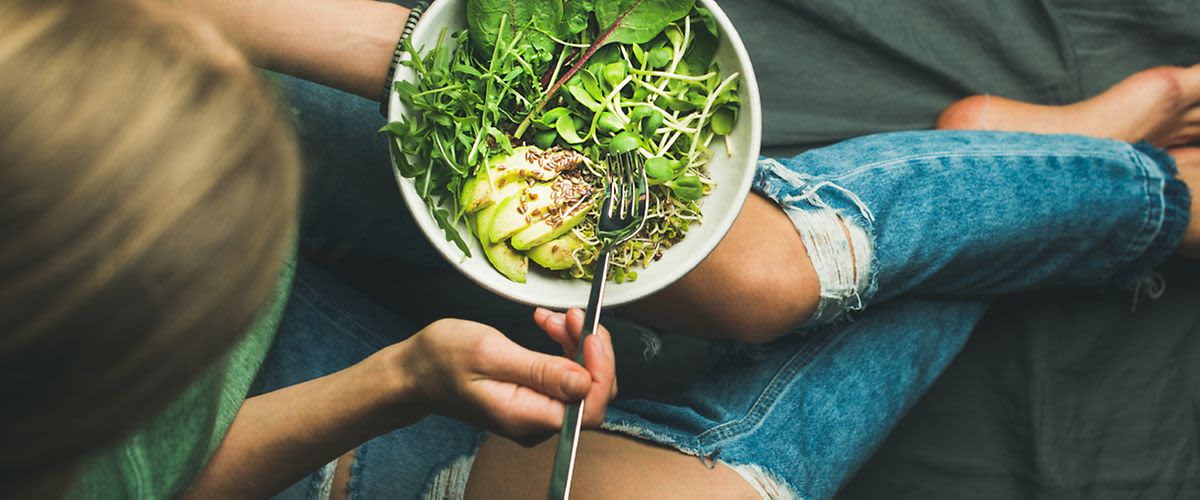 Frau mit Salatschüssel in der Hand beim Essen